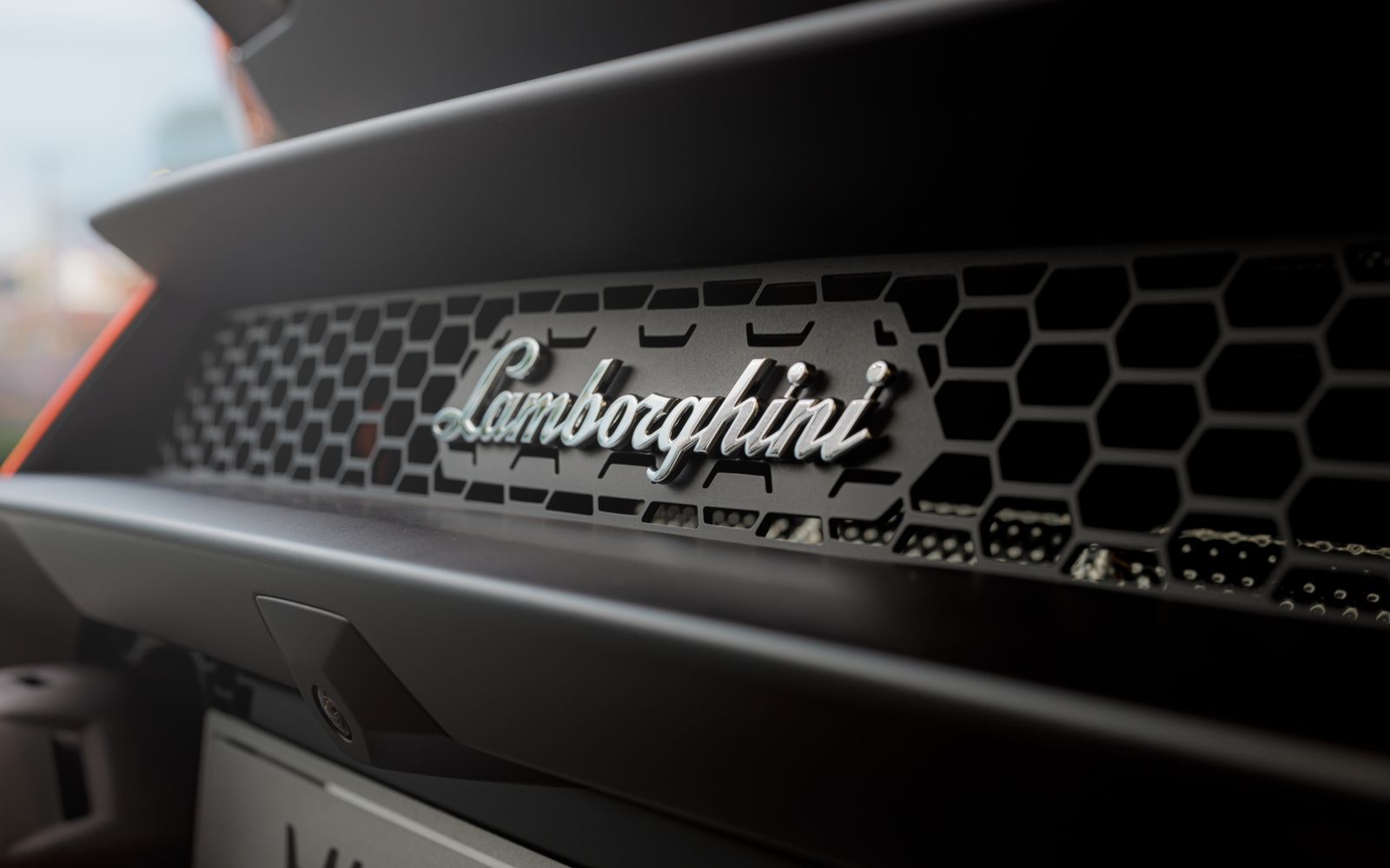 Close-up of a Lamborghini Huracan grille showcasing the luxury sports car emblem.