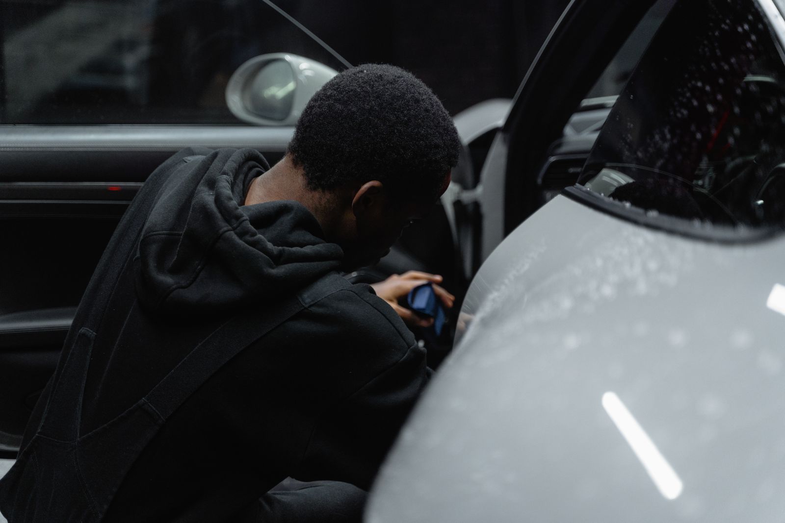 Team member detailing the interior of a luxury car