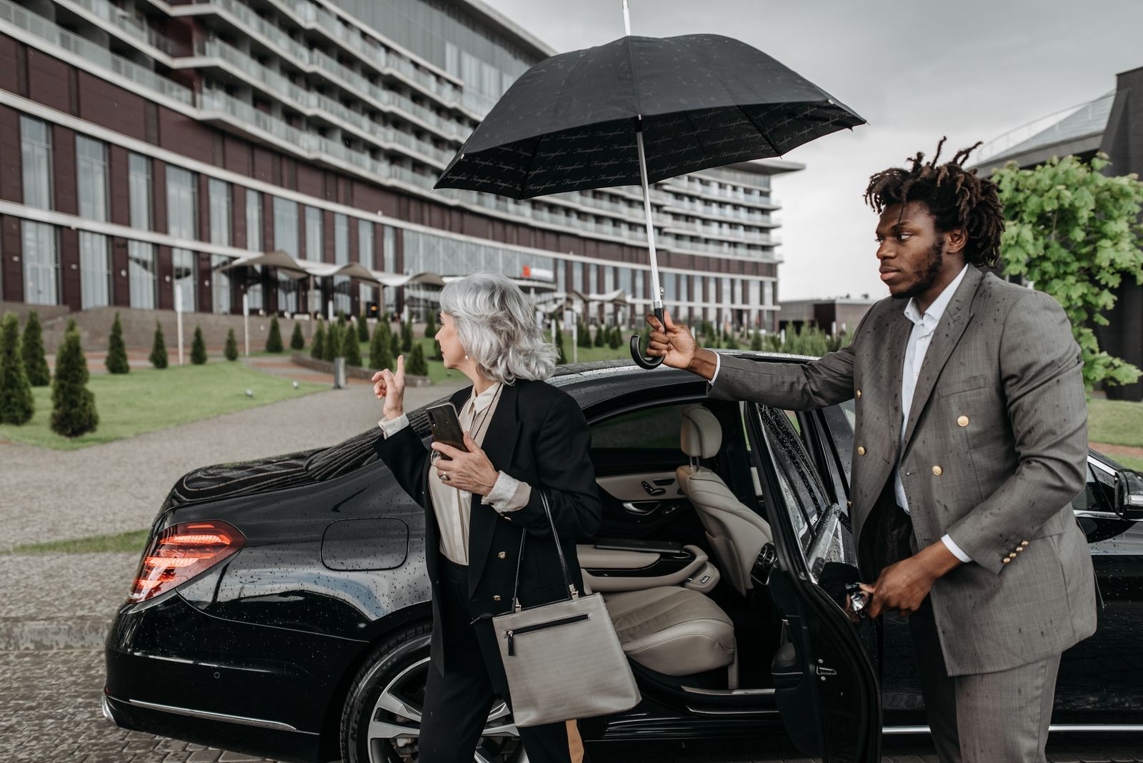 Business professionals stepping out of a luxury car